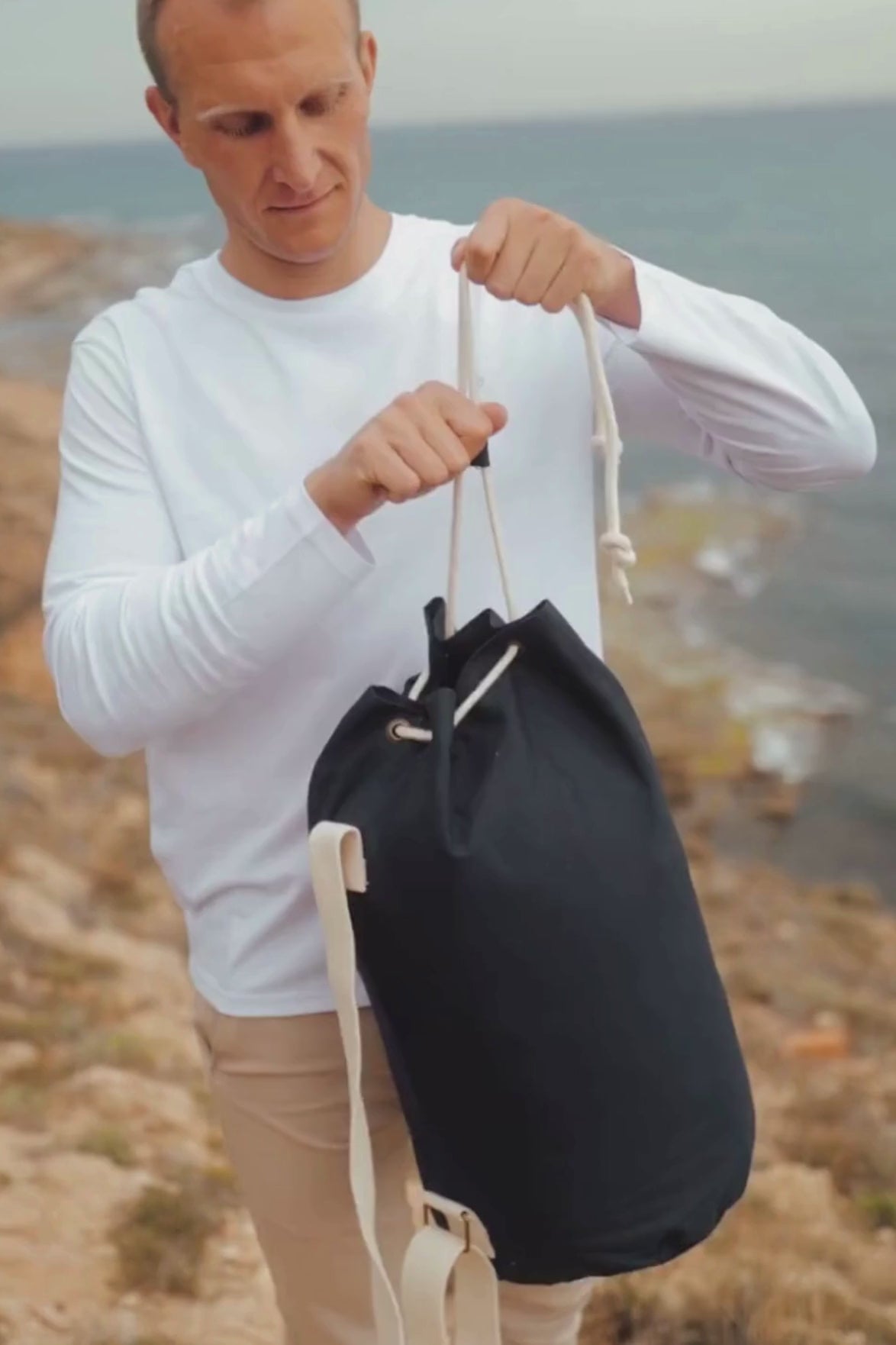 Marine plátěná taška z biobavlny námořní modrá muž stojí na útesu kde si přehazuje tašku přes rameno