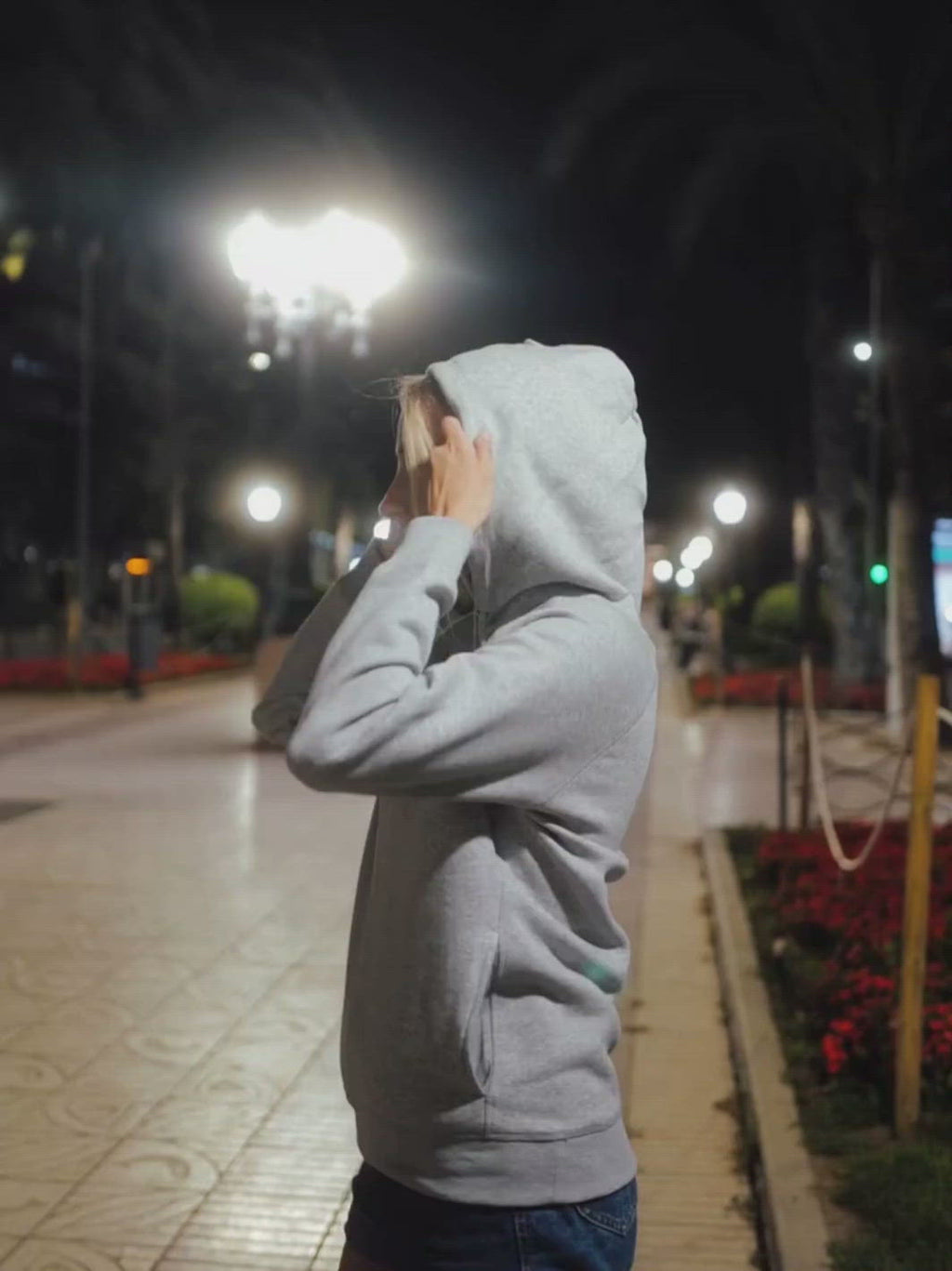 Side dámská mikina s kapucí a kapsami z biobavlny šedá holka v noci si strčí ruce do kapsy